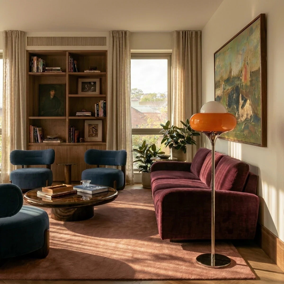 A Clérachic floor lamp in orange glass stands beside a burgundy sofa under a framed painting.