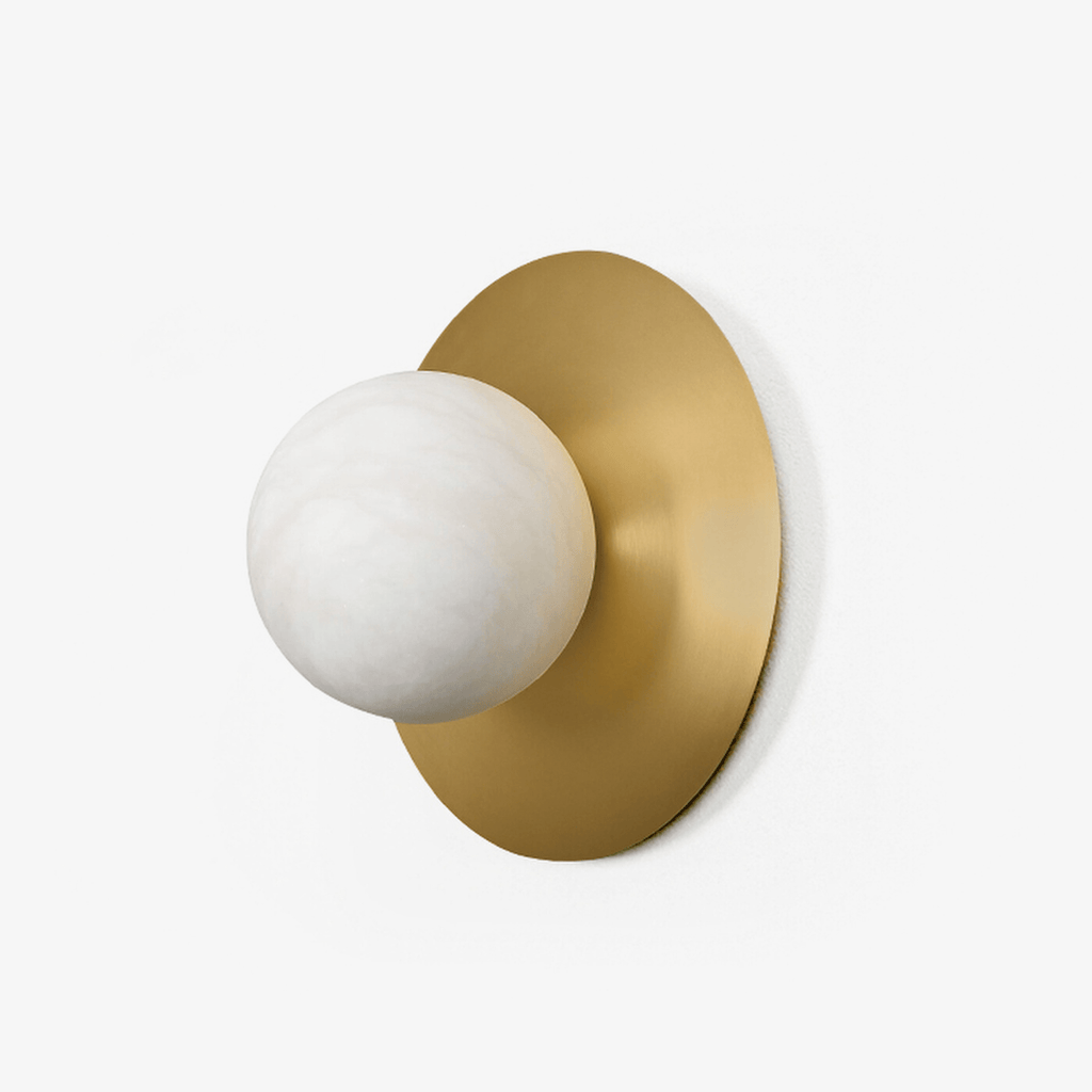 The Clérachic Orb alabaster and brass sconce on white, globe offset to one side of the disc.