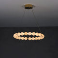 Clérachic Orb ring chandelier on a charcoal wall, a single ring of alabaster beads on brass.