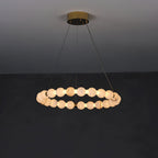 Clérachic Orb ring chandelier on a charcoal wall, a single ring of alabaster beads on brass.