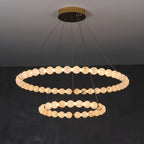 The Clérachic Orb chandelier with two stacked rings of alabaster beads on a brass canopy.