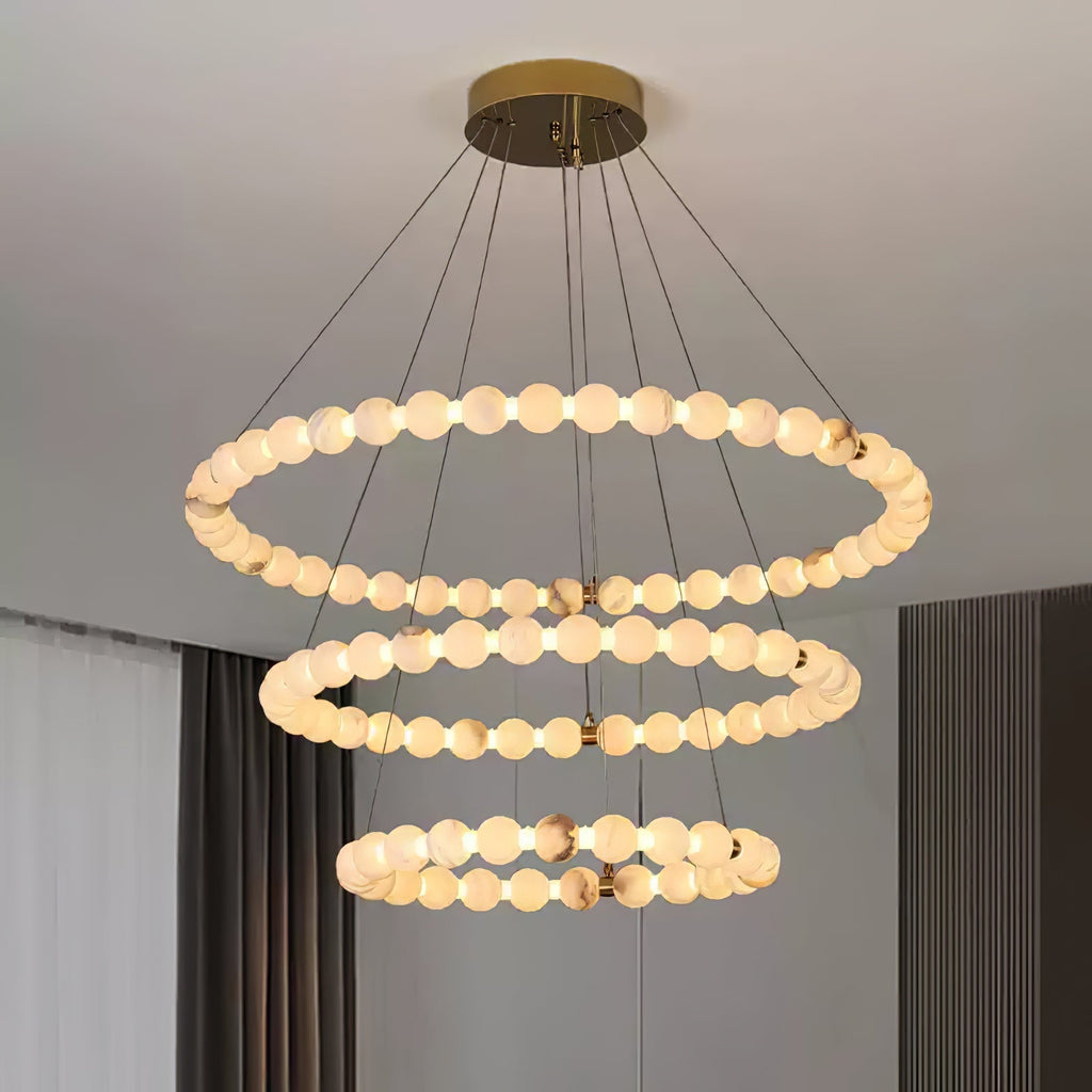 Clérachic Orb chandelier in three rings beside a curtained window in a soft-toned room.