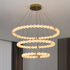 Clérachic Orb chandelier in three rings beside a curtained window in a soft-toned room.
