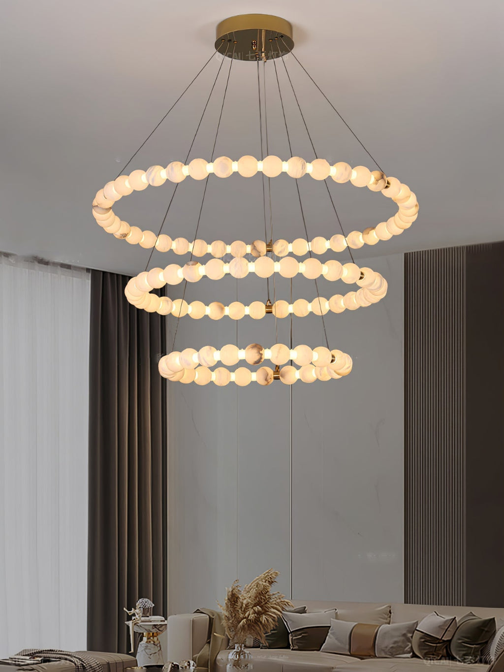 Clérachic Orb chandelier in three tiers above a beige lounge with sheer drapes.