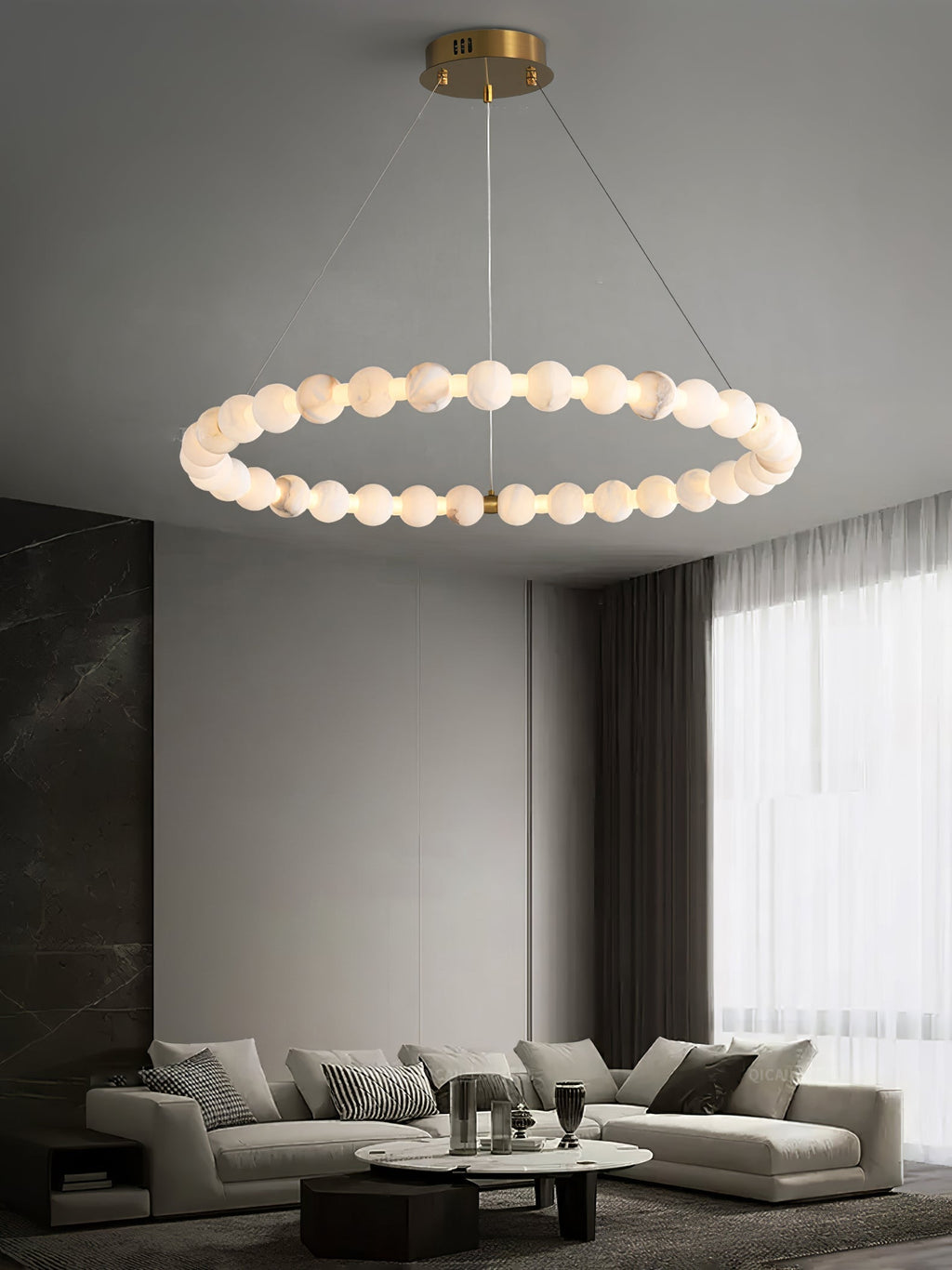 The Clérachic Orb single ring lit above a grey sectional sofa and marble wall.