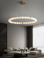 The Clérachic Orb single ring lit above a grey sectional sofa and marble wall.