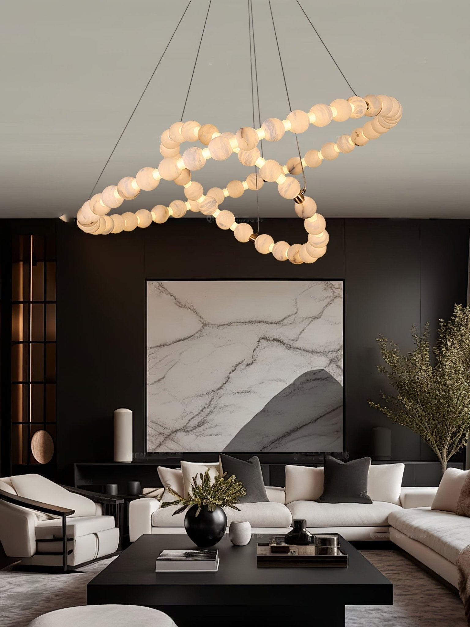 Clérachic Orb chandelier hanging over a dark living room with a marble artwork behind.
