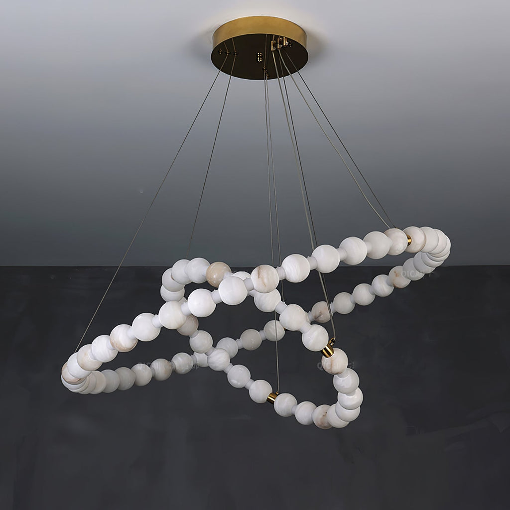 Clérachic Orb chandelier unlit on grey, cool white alabaster beads in a looping spiral.