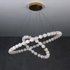 Clérachic Orb chandelier unlit on grey, cool white alabaster beads in a looping spiral.