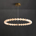 The Clérachic Orb single ring lit on charcoal, an even chain of glowing stone beads.
