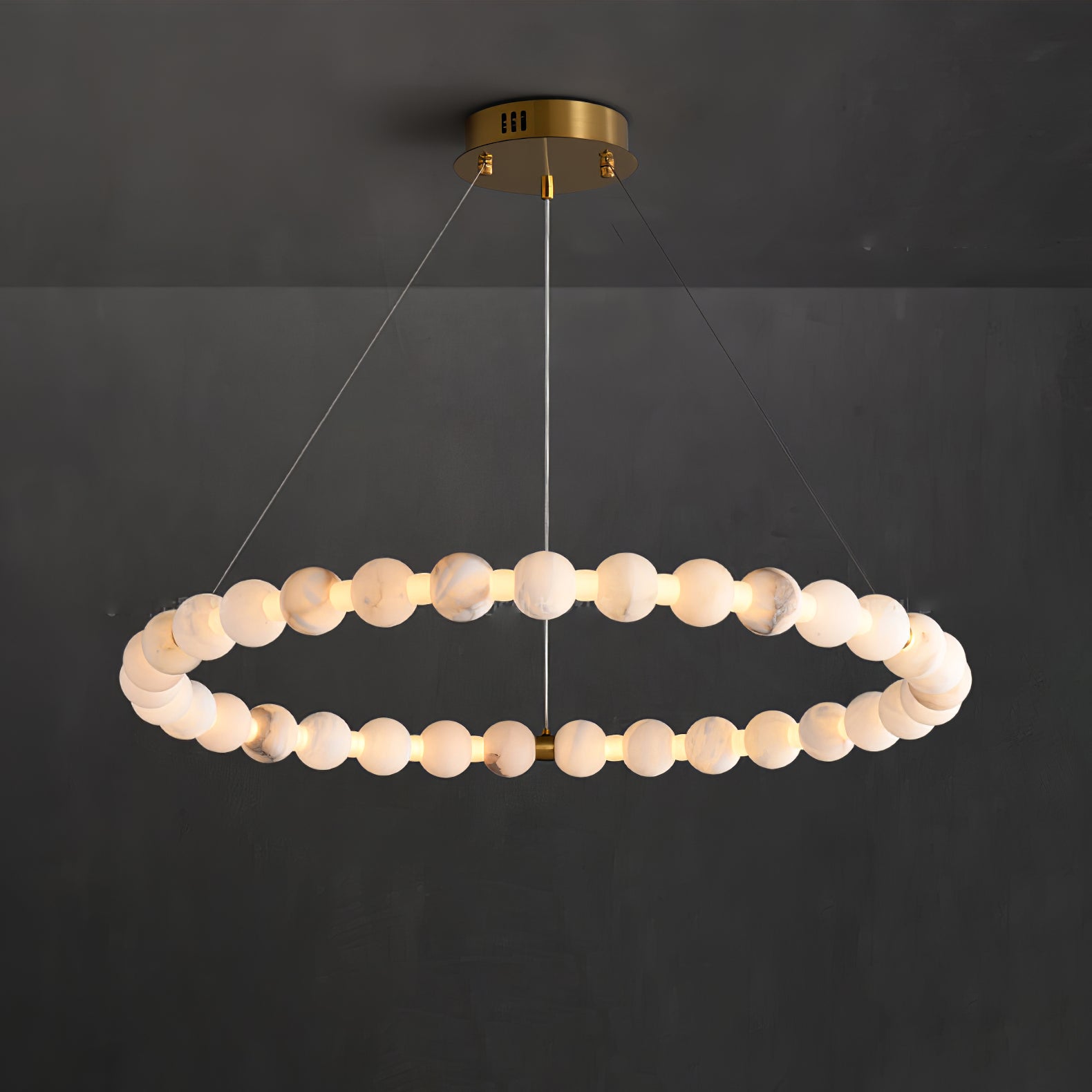 The Clérachic Orb single ring lit on charcoal, an even chain of glowing stone beads.