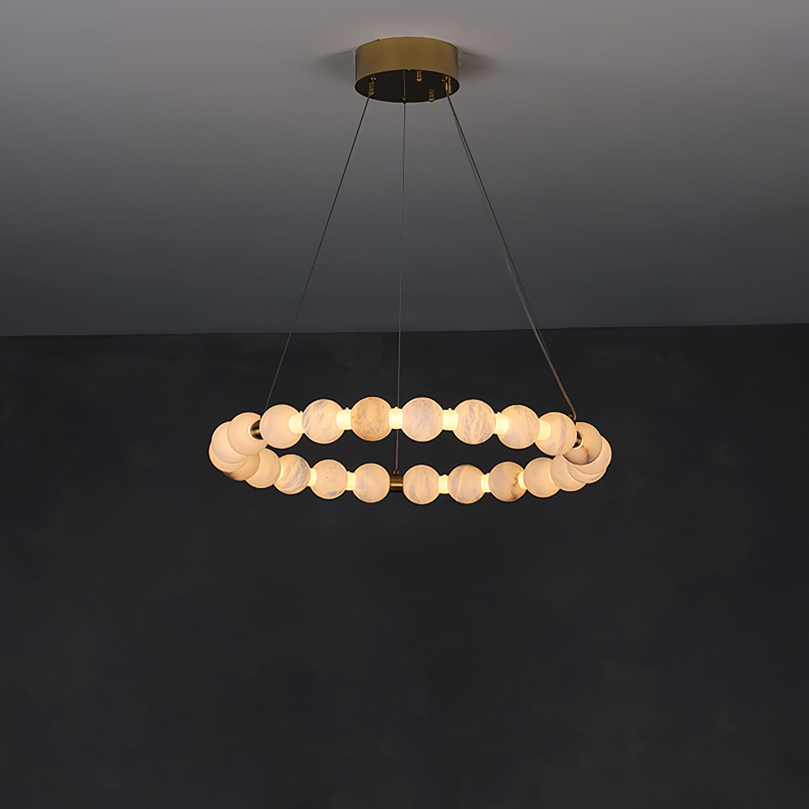 Clérachic Orb ring chandelier lit on grey, a level circle of stone beads on slim cables.