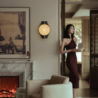 Clérachic Orb sconce lighting a living room with a marble fireplace and open garden doors.