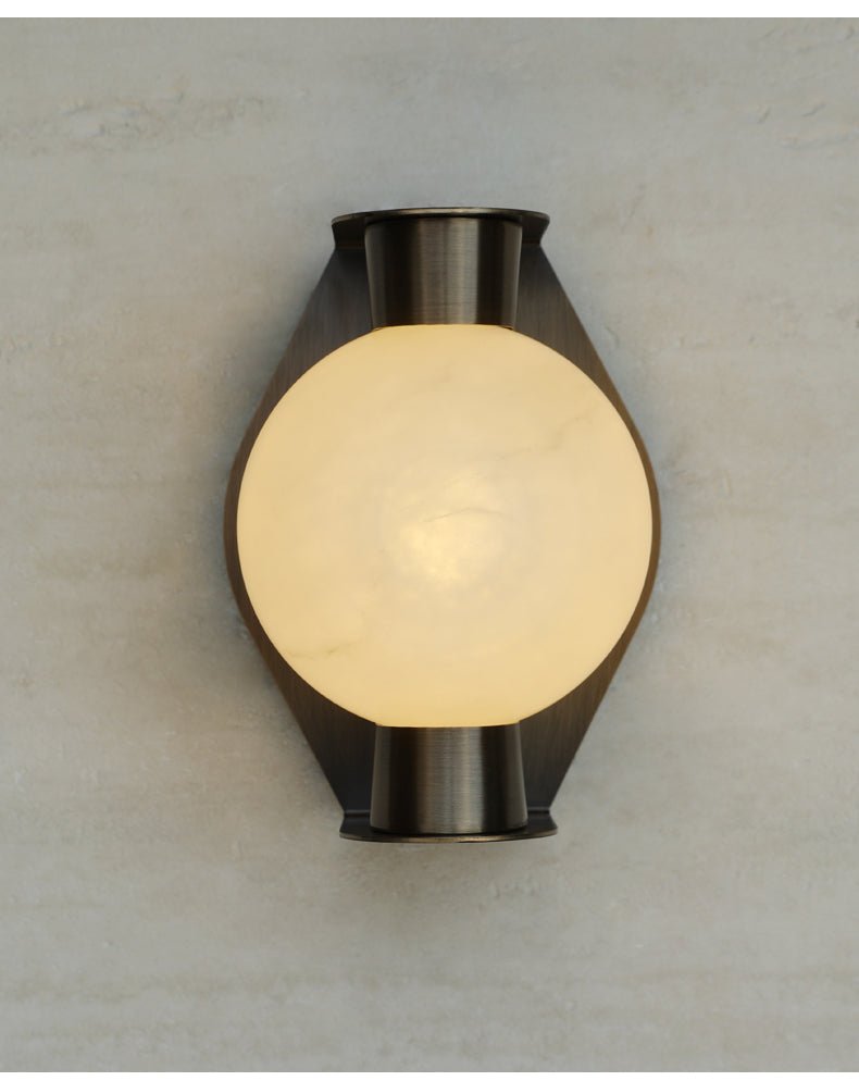 Clérachic Orb sconce photographed straight on, bronze plate framing the lit alabaster globe.