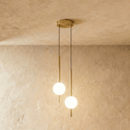 Clérachic twin-head orb pendant light in brushed brass, two rods and globes dropping from one round canopy.