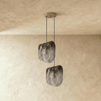 Clérachic two-head pendant of folded smoke-grey glass shades at staggered heights from one round ceiling canopy.