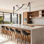 Four-head Clérachic Orinos cluster on black straps lighting a walnut and marble kitchen island with bar stools.