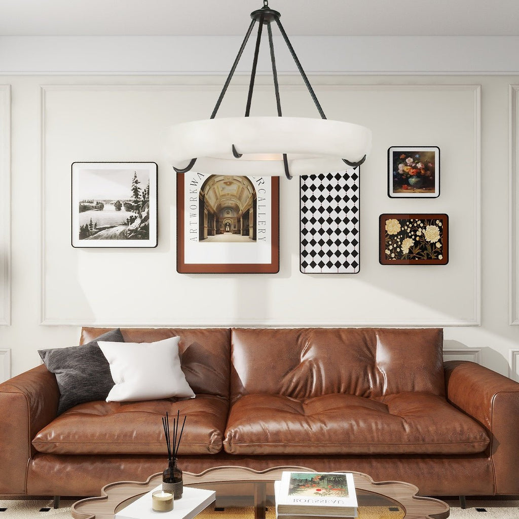 The Clérachic Orion hung over a tan leather sofa and gallery wall, warm light on the plaster.
