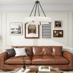 The Clérachic Orion hung over a tan leather sofa and gallery wall, warm light on the plaster.