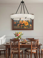 Clérachic Orion chandelier above a wooden dining table set with roses and lit candles.