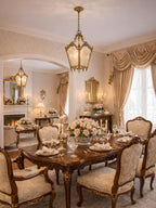 Brass lantern with frosted panes hung in a formal dining room set with flowers and glassware, from Clérachic.