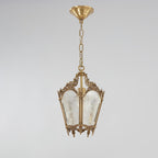 Brass lantern pendant with a round ceiling canopy and a long chain, shown against a pale grey backdrop, from Clérachic.