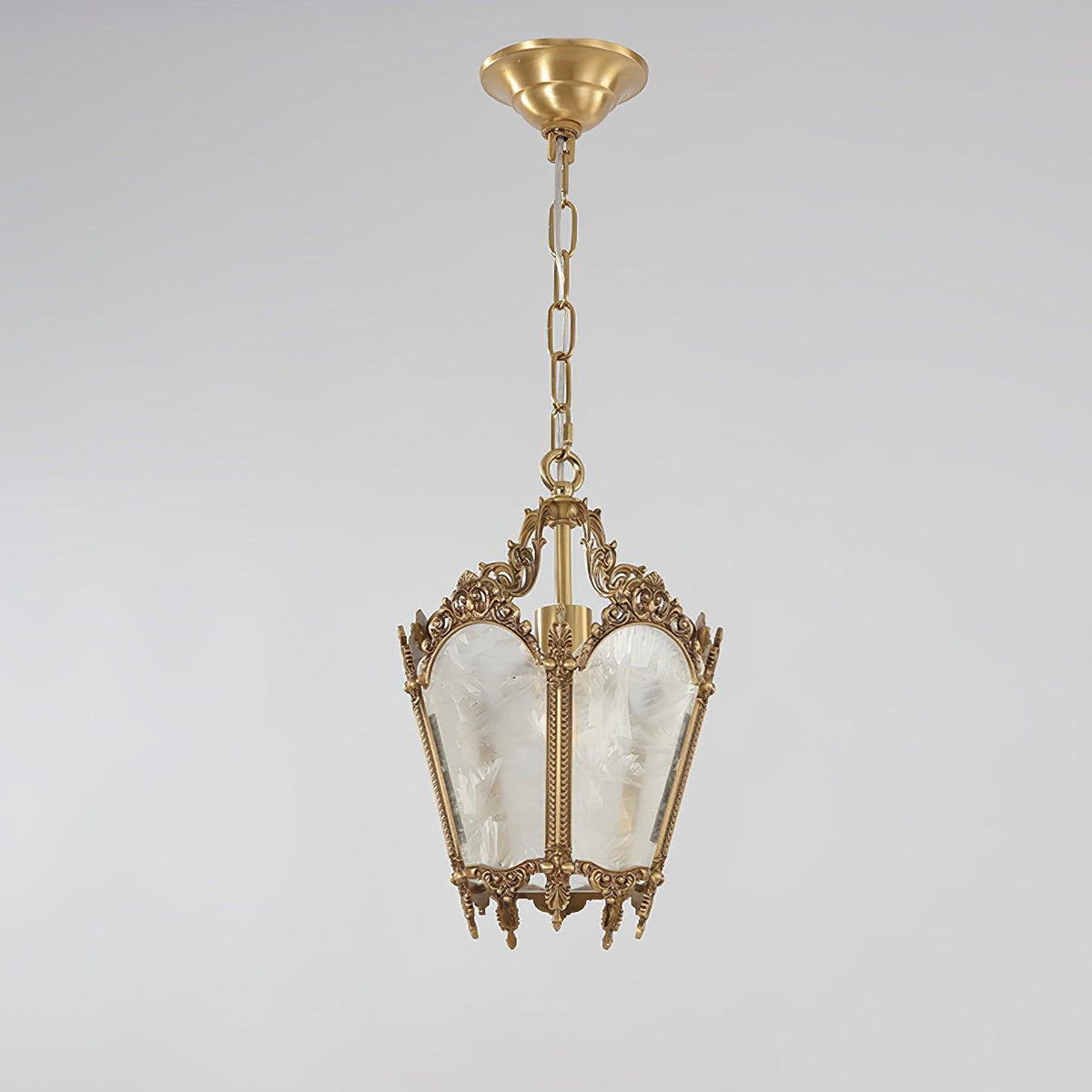 Brass lantern pendant with a round ceiling canopy and a long chain, shown against a pale grey backdrop, from Clérachic.