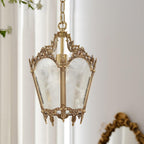 Clérachic brass lantern pendant against white curtains, its ornate frame and frosted panes shown from slightly below.