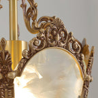 Close view of the scrolled brass crown and the brass stem above one frosted pane on this Clérachic lantern.