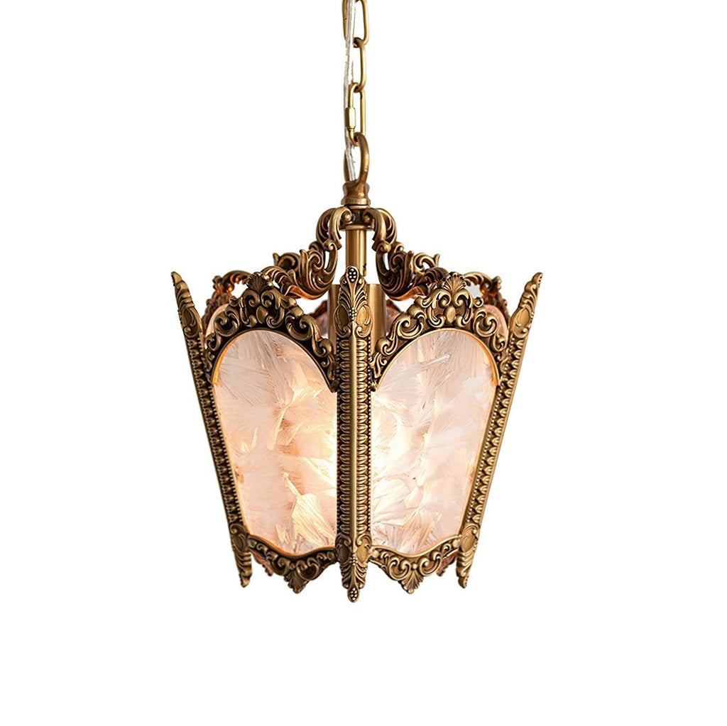Front view of a brass lantern with intricate cast scrollwork and frosted panes, on a plain white backdrop, from Clérachic.