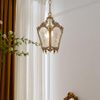 Clérachic brass lantern pendant hung by tall white curtains with a mustard drape and a flowering branch.