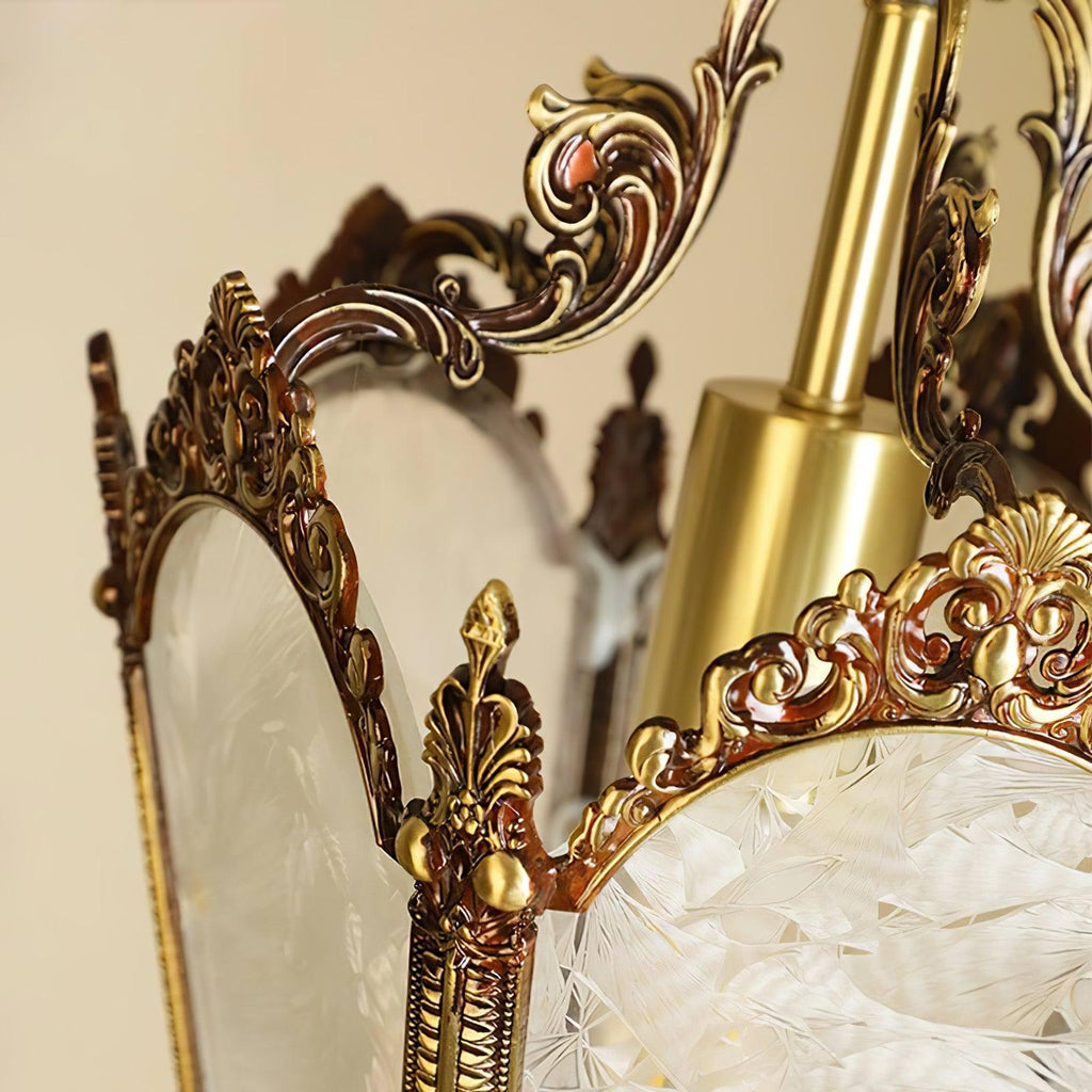 Close view of the cast brass scrolls and acanthus-like finial where two frosted panes meet, on this Clérachic lantern.