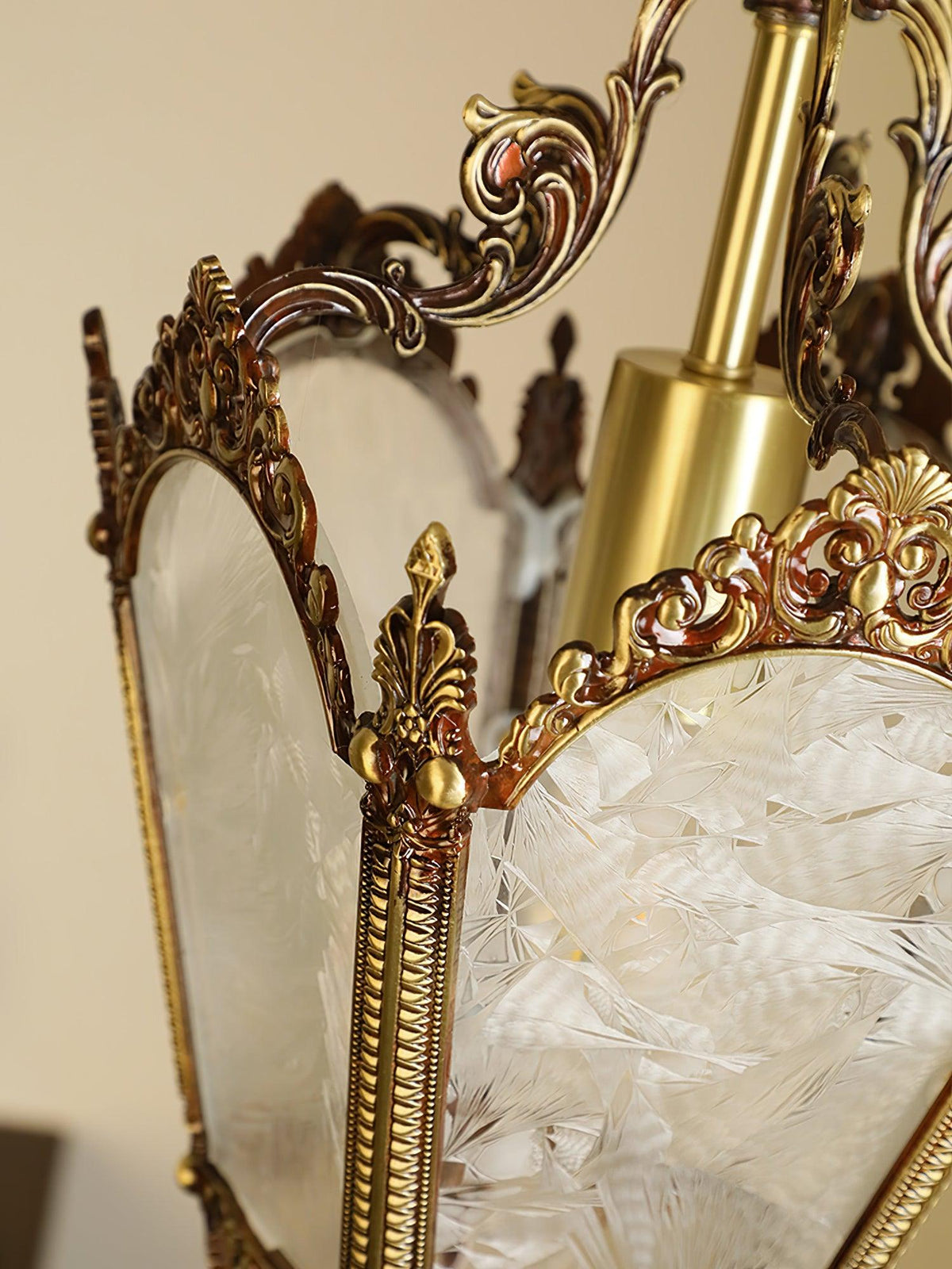 Close view of the frosted glass panes, brass post and scrolled crown at the top of this Clérachic lantern.