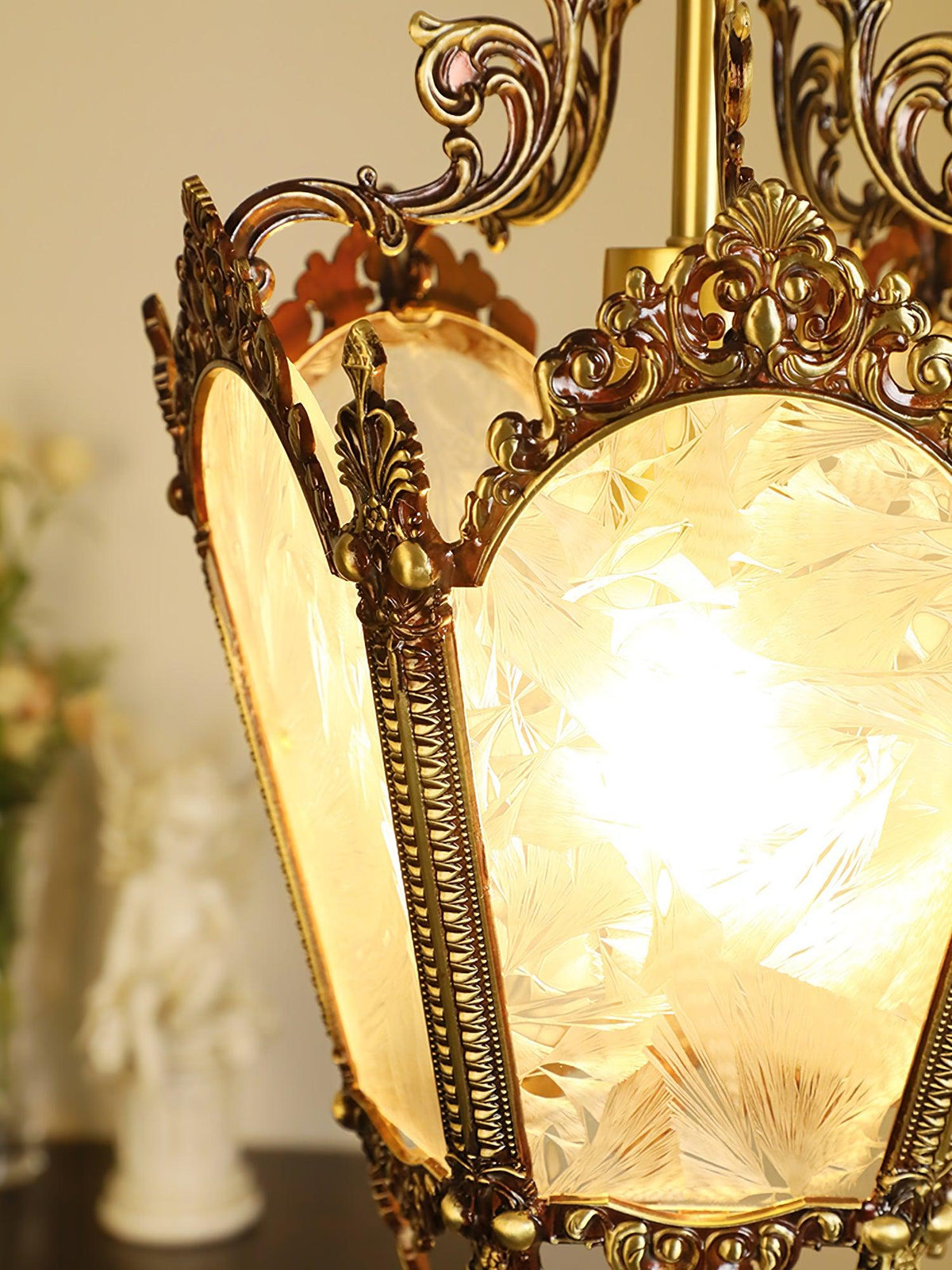 Close view of the glowing frosted panes and cast brass frame on this lit Clérachic lantern pendant.