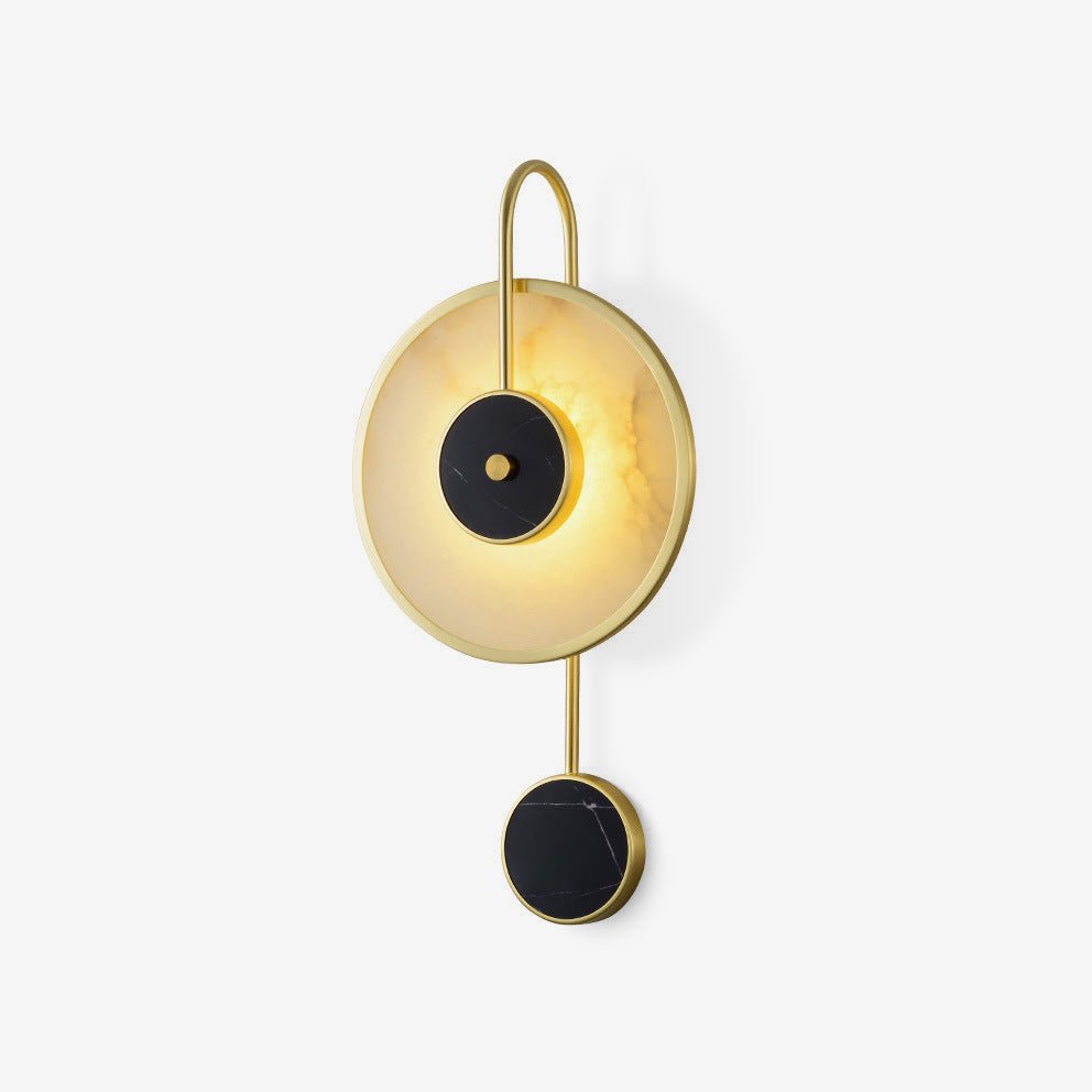 Clérachic Orphaa seen at an angle so the curved brass hook arching over the glowing alabaster disc reads clearly.