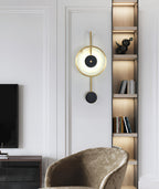 Clérachic Orphaa on a white panelled living room wall, lit alongside a warm oak shelving niche.