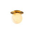 The Clérachic Orrila mounted as a ceiling light on white, globe hanging below the brass disc.