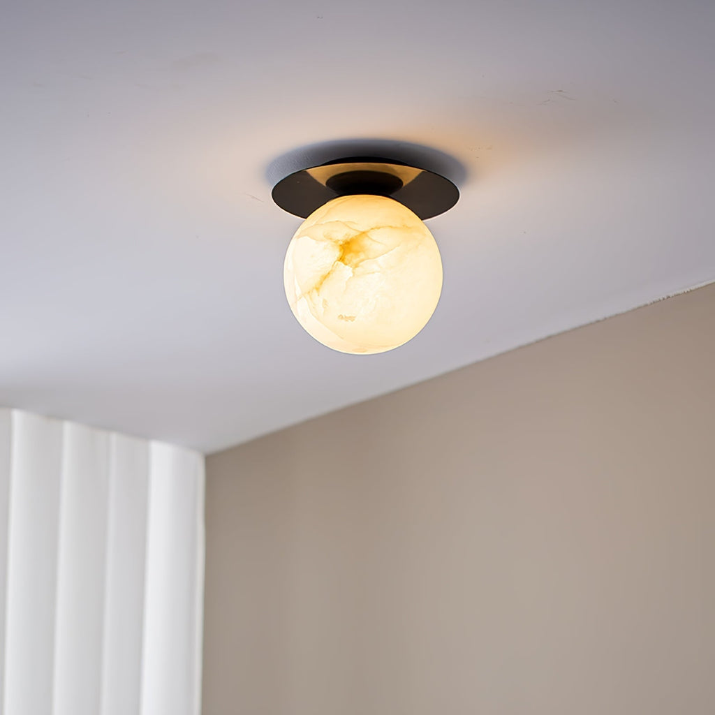 Clérachic Orrila in black finish on a ceiling, warm alabaster globe below the dark disc.