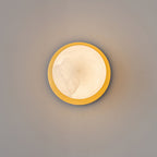 Clérachic Orrila seen straight on, brass ring encircling the lit alabaster face.
