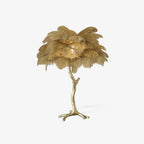 Clérachic ostrich feather table lamp with a gold-toned plume shade on a branch-shaped brass stem with splayed feet, on a plain white background.