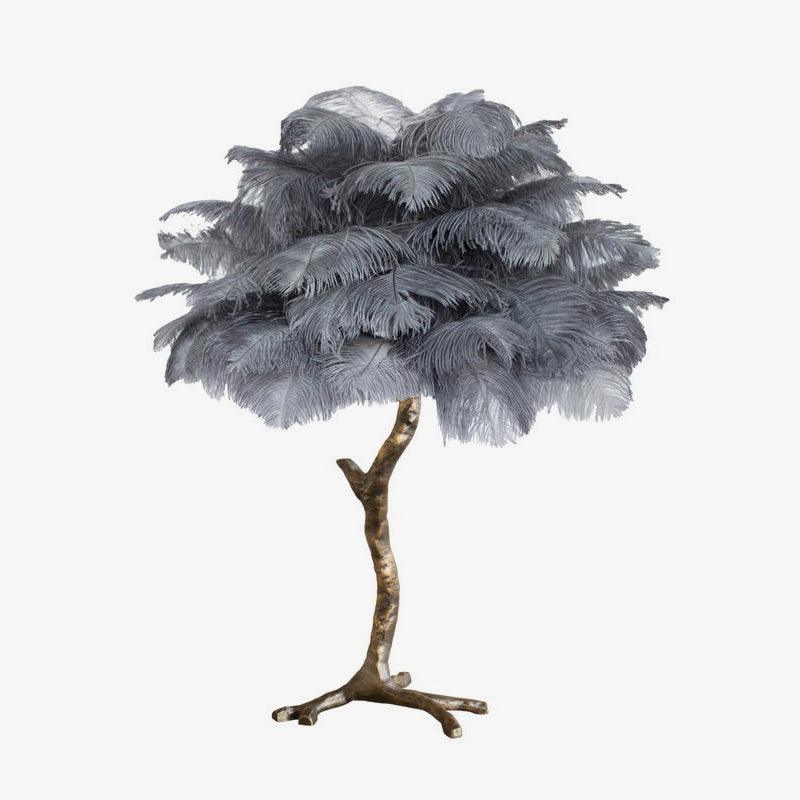 Clérachic table lamp with layered grey ostrich feathers on a bronze-toned branch stem and splayed feet, on a plain white background.