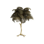 Clérachic table lamp with dark olive-brown feathers on a gold branch stem with splayed feet, on a white background.