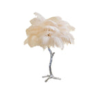 Clérachic table lamp with a cream-coloured feather shade on a silver branch stem with splayed feet, on a plain white background.