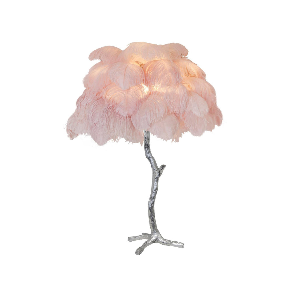 Clérachic table lamp with lit blush-pink feathers on a silver branch stem and splayed feet, on a white background.