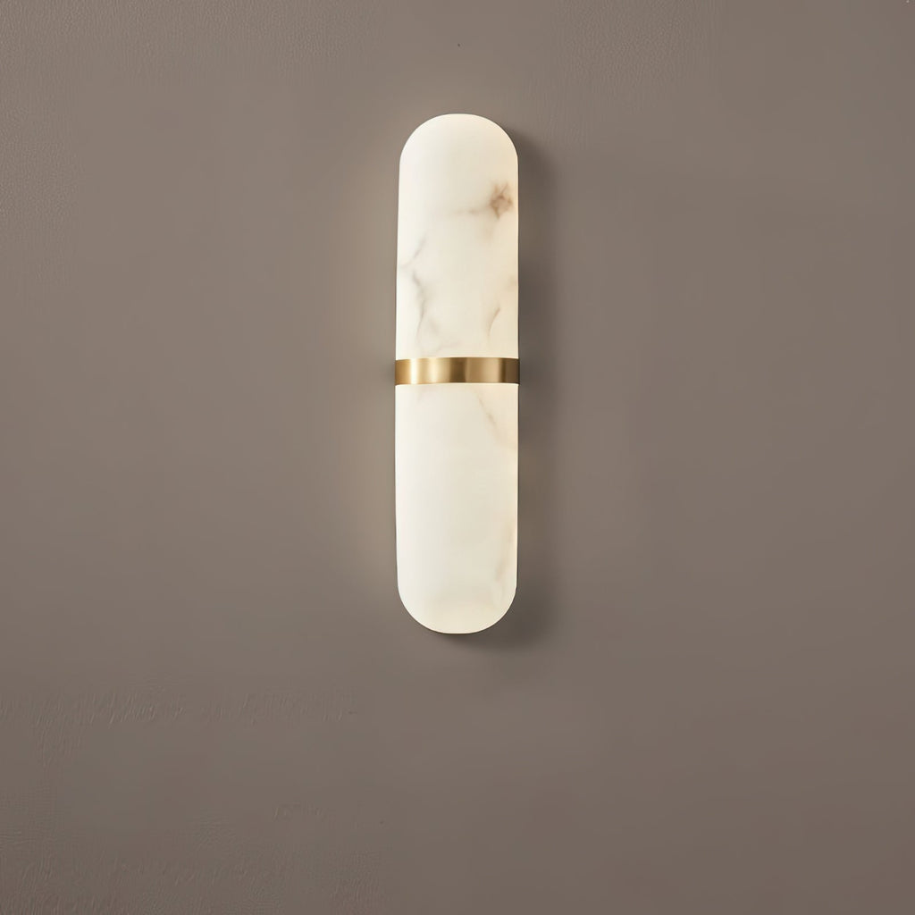 The Clérachic Ostruvyd in its slimmer size, pale alabaster and brass, casting a soft shadow down a mocha-brown wall.