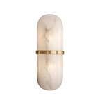 The Clérachic Ostruvyd lit on a plain white backdrop, warm light pooling behind the grey-veined alabaster panel.