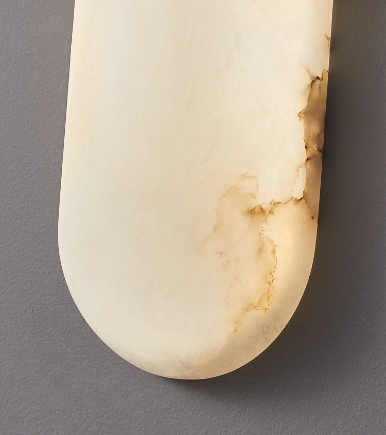 Close-up of the Clérachic alabaster shade's rounded end, amber veining running through the polished stone.