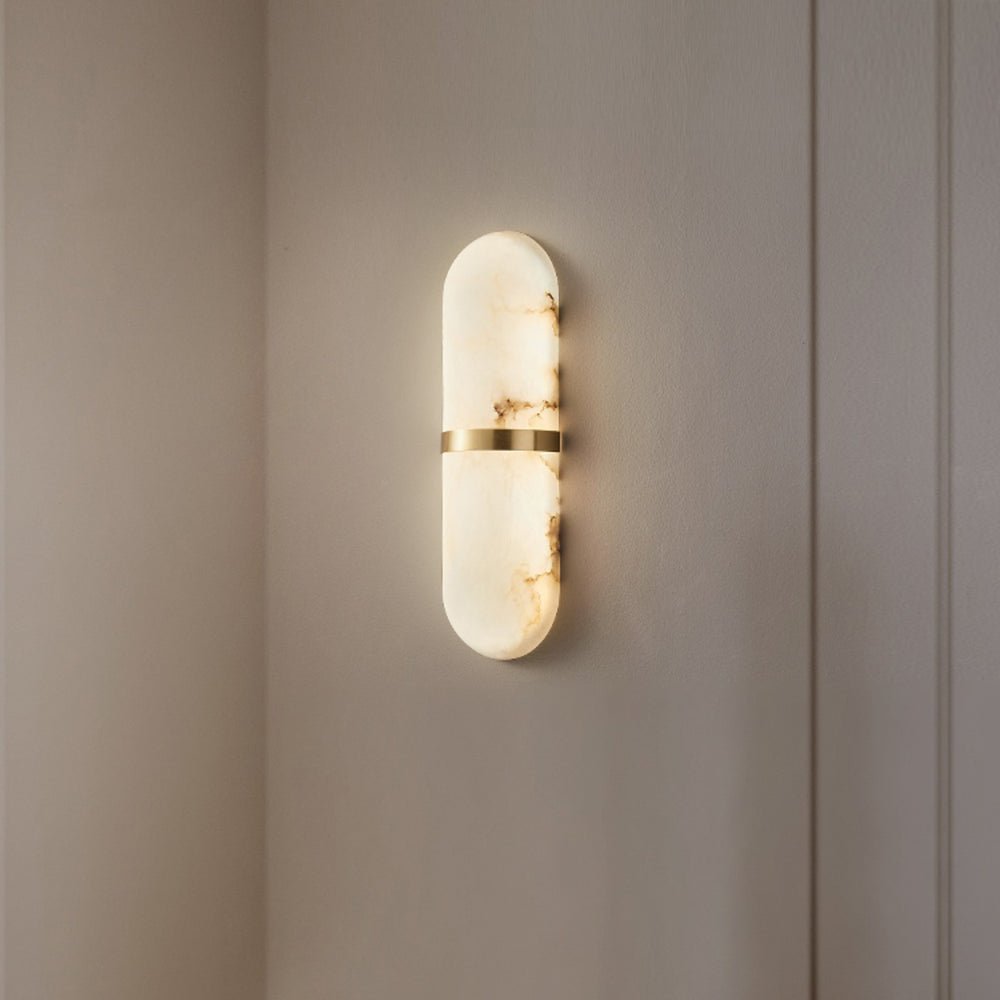 The Clérachic Ostruvyd alight on a plain warm-white wall beside a door casing, brass band glinting.