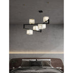 The Clérachic Ostruvye over a made bed, warm cube light layered with the cove lighting in the ceiling.