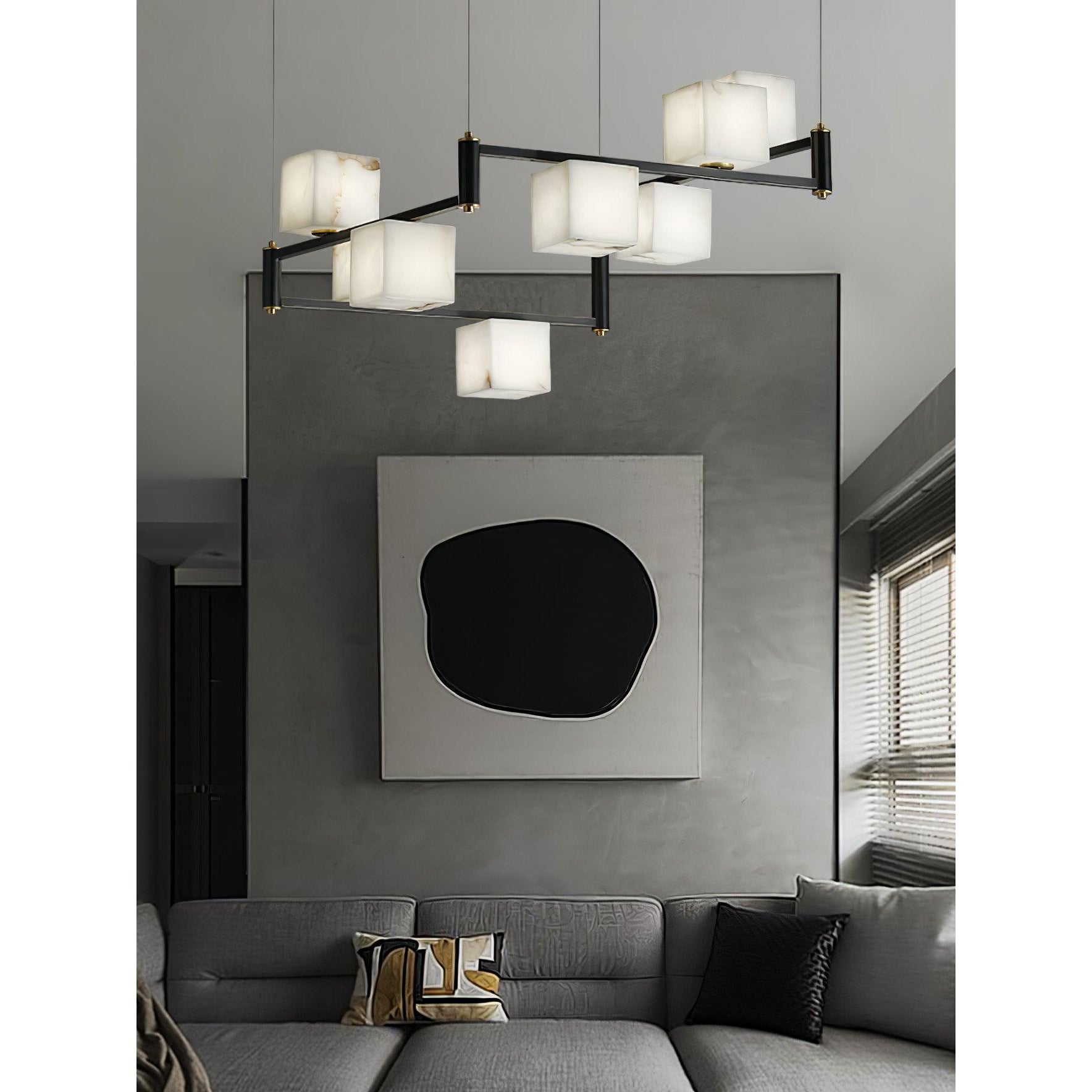 Clérachic box chandelier in front of a large abstract canvas, floating above a low grey sectional.